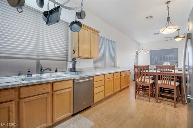 kitchen featuring decorative light fixtures, light brown cabinetry, stainless steel dishwasher, light hardwood / wood-style flooring, and sink