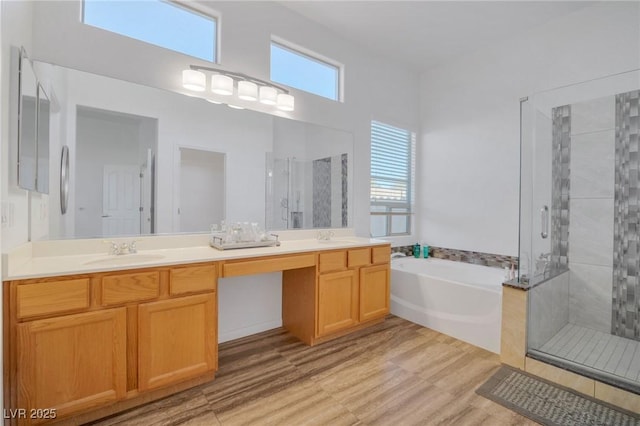 bathroom featuring shower with separate bathtub, hardwood / wood-style floors, and vanity