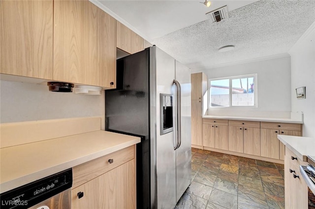 kitchen with a textured ceiling, appliances with stainless steel finishes, and light brown cabinetry