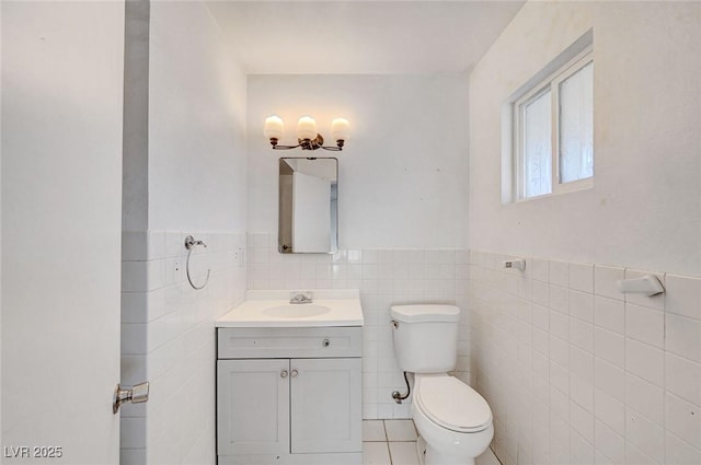 bathroom featuring tile patterned floors, tile walls, toilet, and vanity