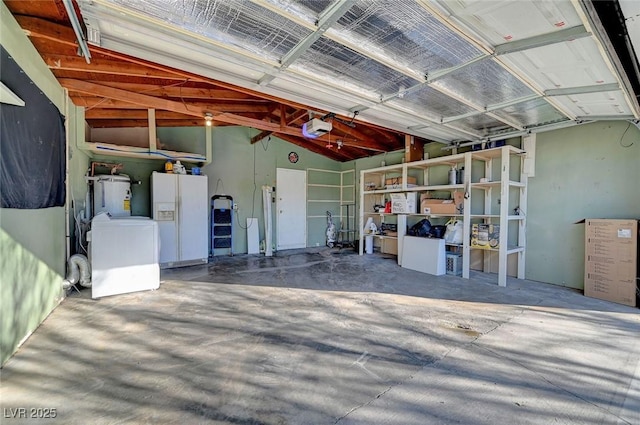 garage featuring white refrigerator with ice dispenser, washer / dryer, water heater, and a garage door opener