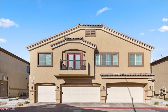 mediterranean / spanish-style house featuring a garage, a balcony, and central air condition unit