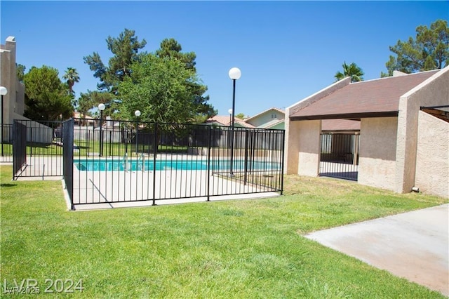 view of pool with a patio area and a lawn