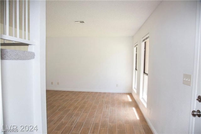 empty room with hardwood / wood-style flooring and a wealth of natural light