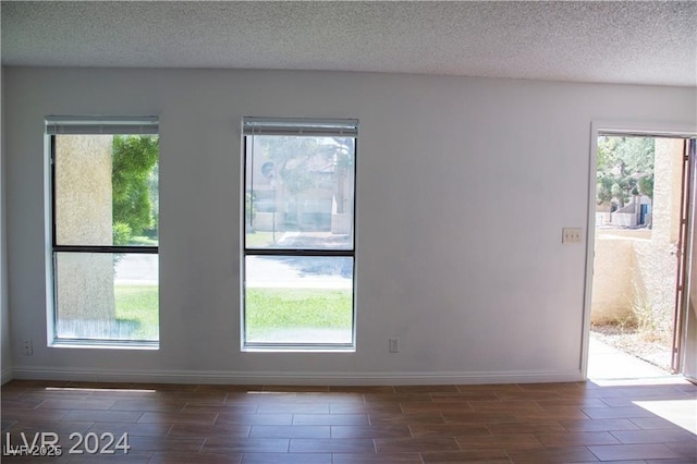 spare room featuring a healthy amount of sunlight and a textured ceiling