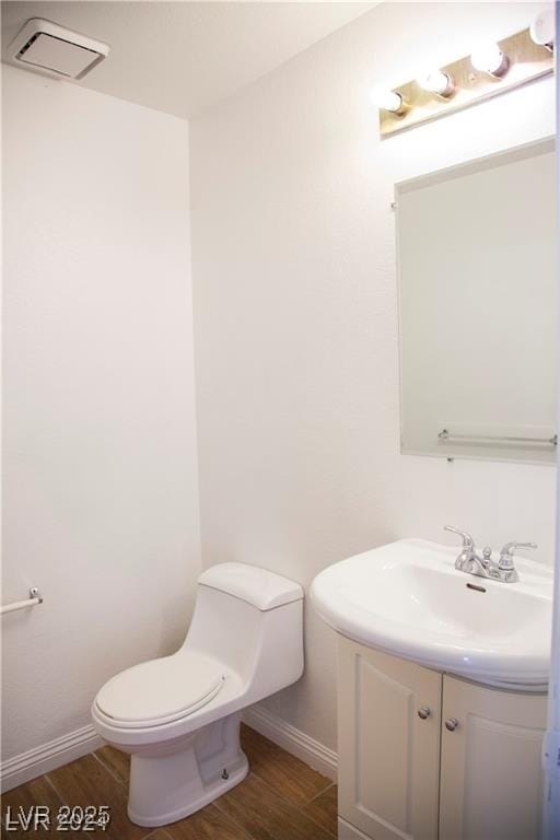 bathroom featuring hardwood / wood-style flooring, toilet, and vanity