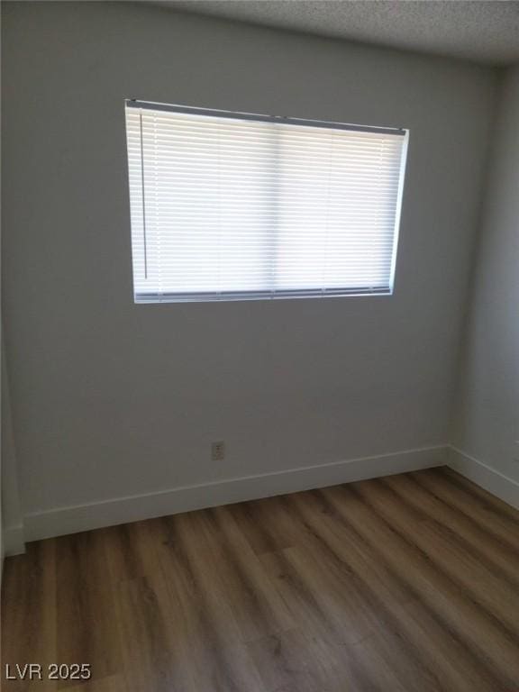 spare room featuring hardwood / wood-style flooring and a textured ceiling