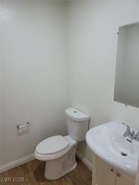 bathroom featuring sink, wood-type flooring, and toilet