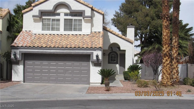 mediterranean / spanish home featuring driveway, a chimney, a tiled roof, an attached garage, and stucco siding