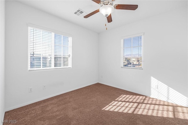 empty room featuring carpet floors, a healthy amount of sunlight, and ceiling fan