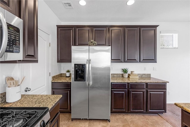 kitchen with light stone countertops, dark brown cabinetry, and stainless steel appliances