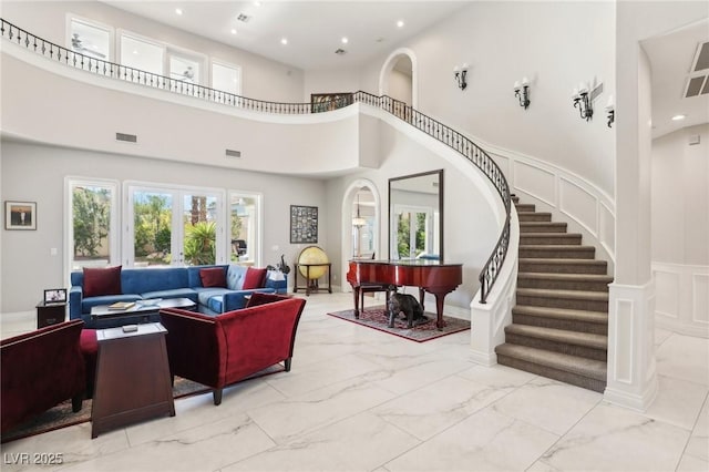 interior space featuring french doors, a wealth of natural light, and a high ceiling