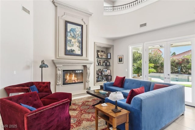 living room featuring a high ceiling, light tile patterned floors, and french doors