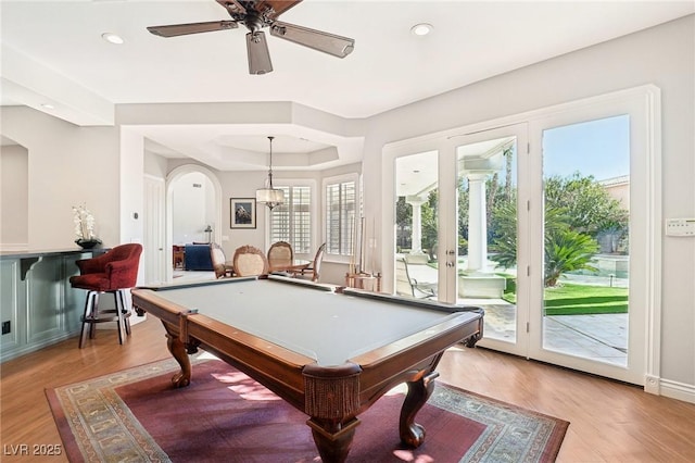 rec room featuring ceiling fan, billiards, a tray ceiling, and light hardwood / wood-style floors