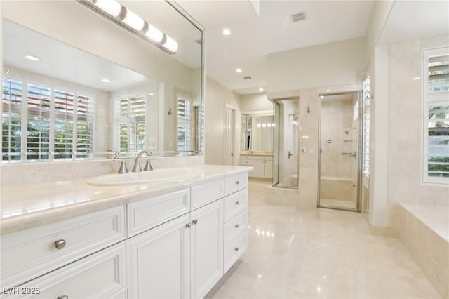 bathroom featuring a shower with door and vanity