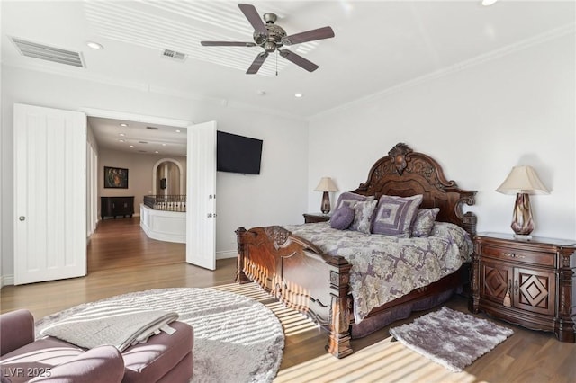 bedroom featuring ceiling fan, hardwood / wood-style floors, and crown molding