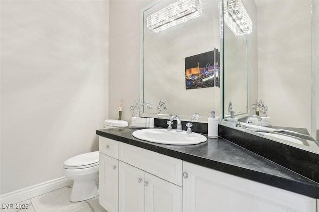 bathroom with toilet, vanity, and tile patterned flooring