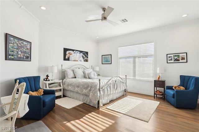 bedroom featuring ceiling fan, hardwood / wood-style floors, and crown molding