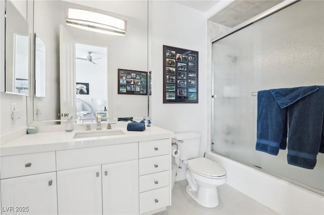 full bathroom featuring toilet, ceiling fan, enclosed tub / shower combo, and vanity