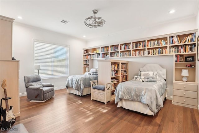 bedroom with hardwood / wood-style floors and ornamental molding