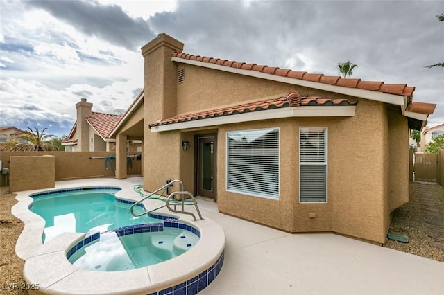 rear view of house with a pool with hot tub and a patio