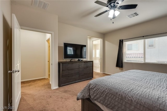 carpeted bedroom with ensuite bath and ceiling fan