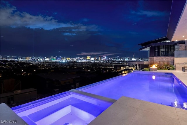 pool at twilight with an in ground hot tub