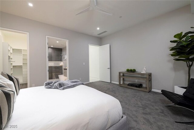 bedroom featuring ceiling fan, ensuite bathroom, a spacious closet, a closet, and dark carpet