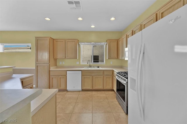 kitchen featuring sink, white appliances, light tile patterned floors, and light brown cabinets