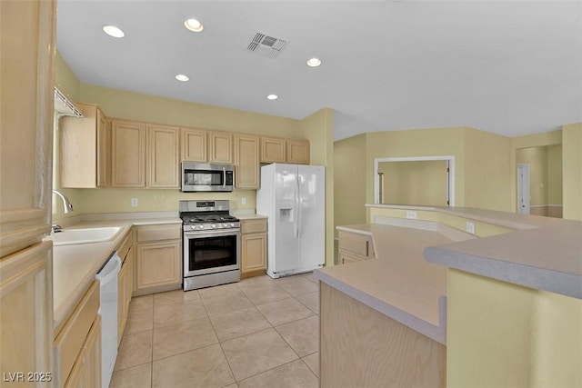 kitchen with light tile patterned floors, stainless steel appliances, sink, and light brown cabinets