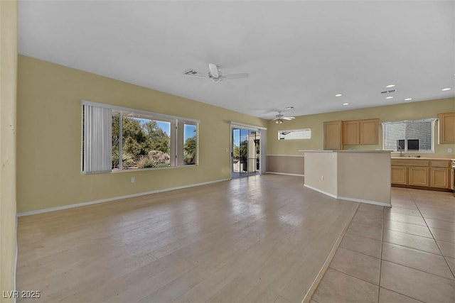 unfurnished living room featuring light wood-type flooring and ceiling fan