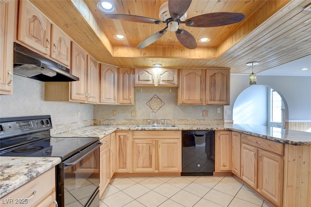 kitchen with light stone countertops, light brown cabinets, a tray ceiling, and black appliances