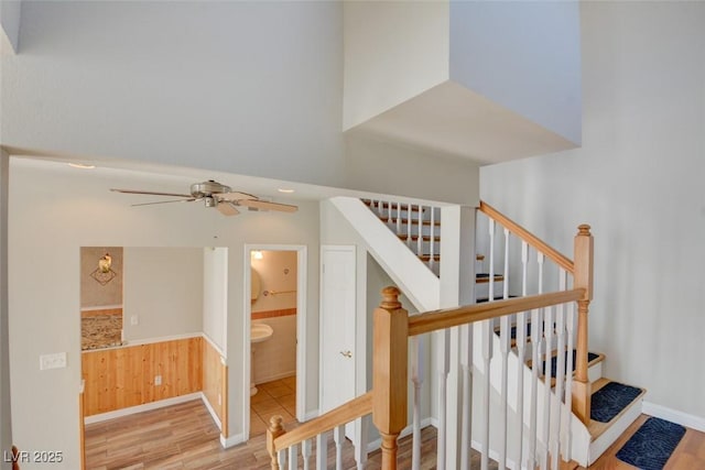 staircase with ceiling fan and hardwood / wood-style flooring