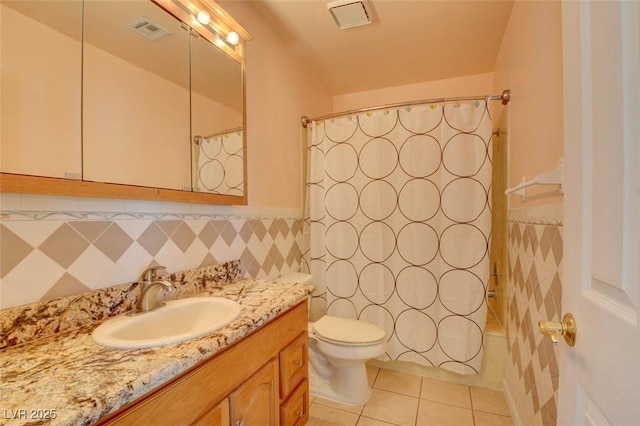 full bathroom featuring toilet, shower / bathtub combination with curtain, tile patterned floors, and vanity