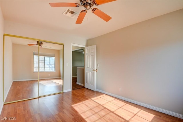 unfurnished bedroom featuring ceiling fan, light hardwood / wood-style floors, and a closet