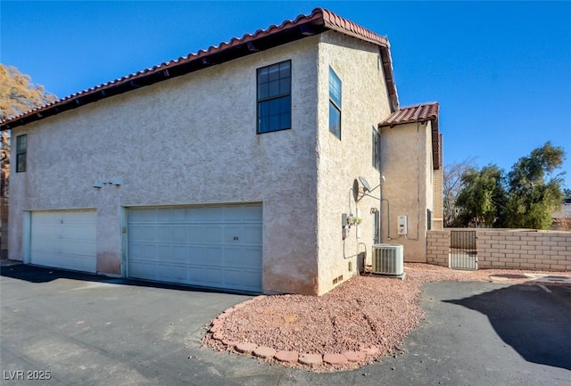 view of side of home featuring a garage and central air condition unit