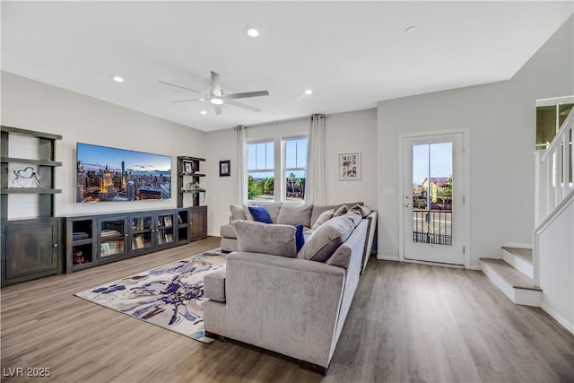 living room featuring wood-type flooring and ceiling fan