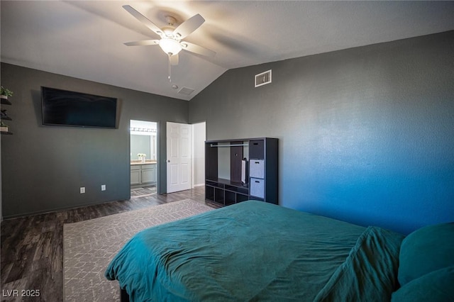 bedroom with lofted ceiling, dark hardwood / wood-style floors, ceiling fan, and connected bathroom