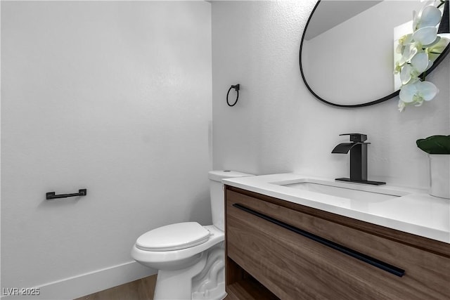 bathroom with wood-type flooring, toilet, and vanity