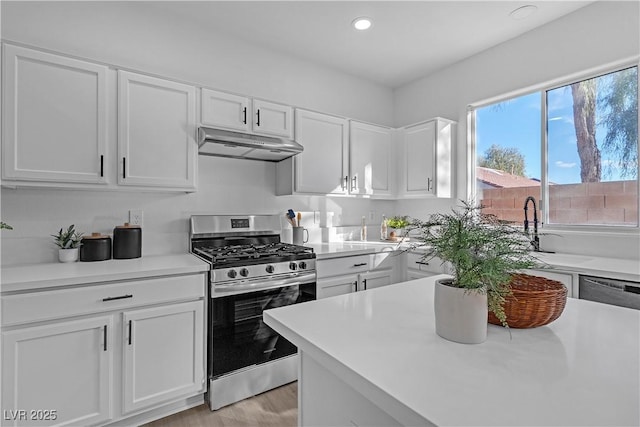 kitchen featuring sink, light wood-type flooring, white cabinetry, and gas stove