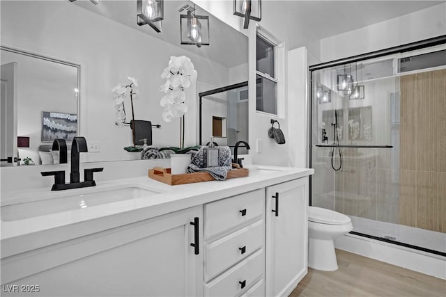 bathroom featuring vanity, toilet, walk in shower, and hardwood / wood-style floors