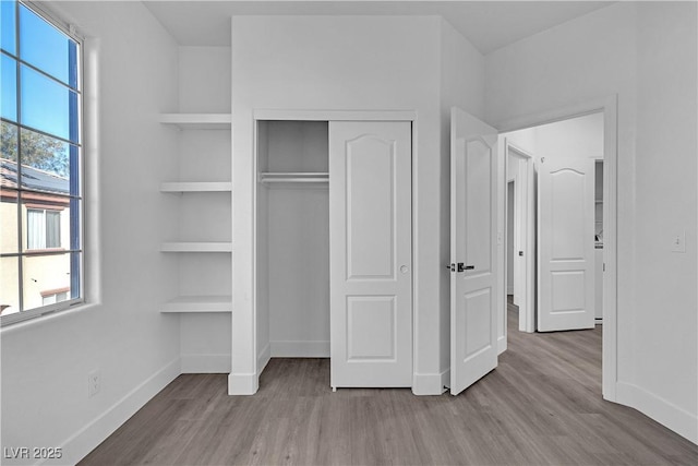 unfurnished bedroom featuring a closet and light wood-type flooring