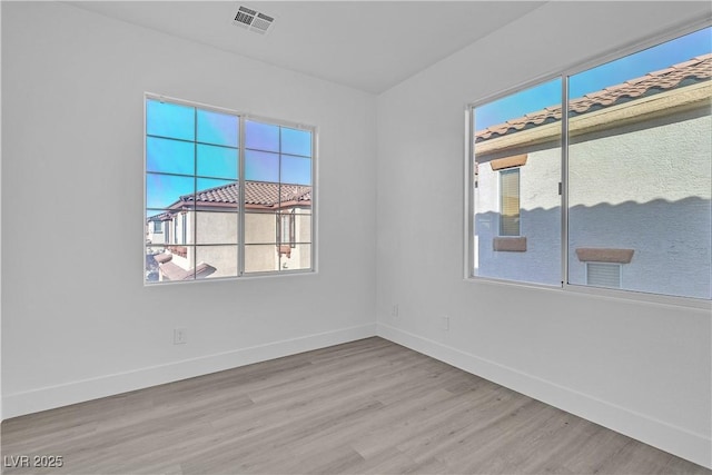 empty room with light hardwood / wood-style flooring