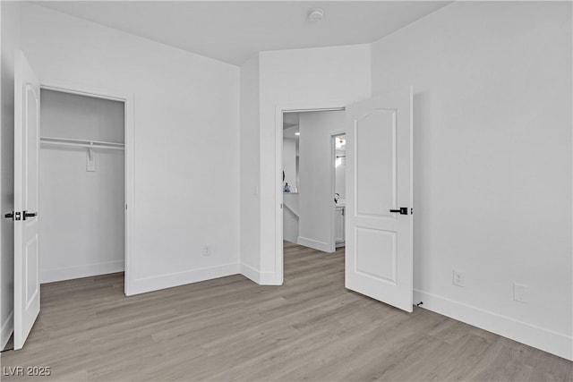 unfurnished bedroom featuring light hardwood / wood-style flooring and a closet