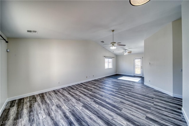 empty room featuring dark wood-type flooring, vaulted ceiling, and ceiling fan