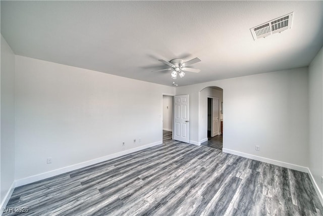 empty room featuring ceiling fan, dark wood-type flooring, and a textured ceiling