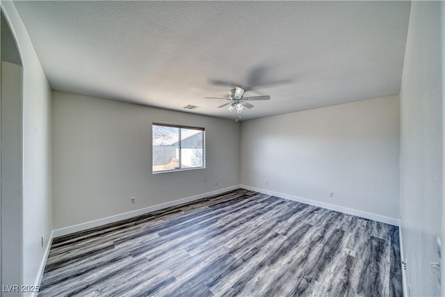 spare room with ceiling fan, a textured ceiling, and wood-type flooring