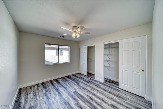 unfurnished bedroom with ceiling fan, two closets, and light wood-type flooring