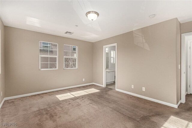 unfurnished bedroom featuring ensuite bath and carpet floors