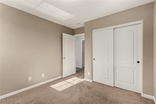 unfurnished bedroom with light colored carpet and a closet